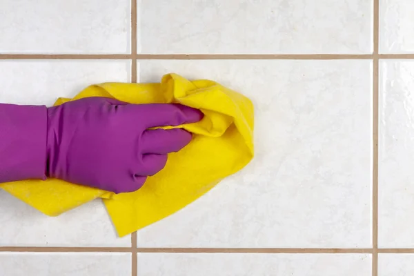 Man wiping tile with microfiber cloth