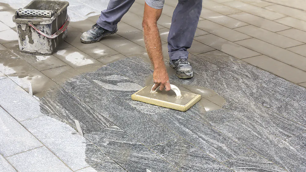 A Man Applying Grout to the Tile Floor